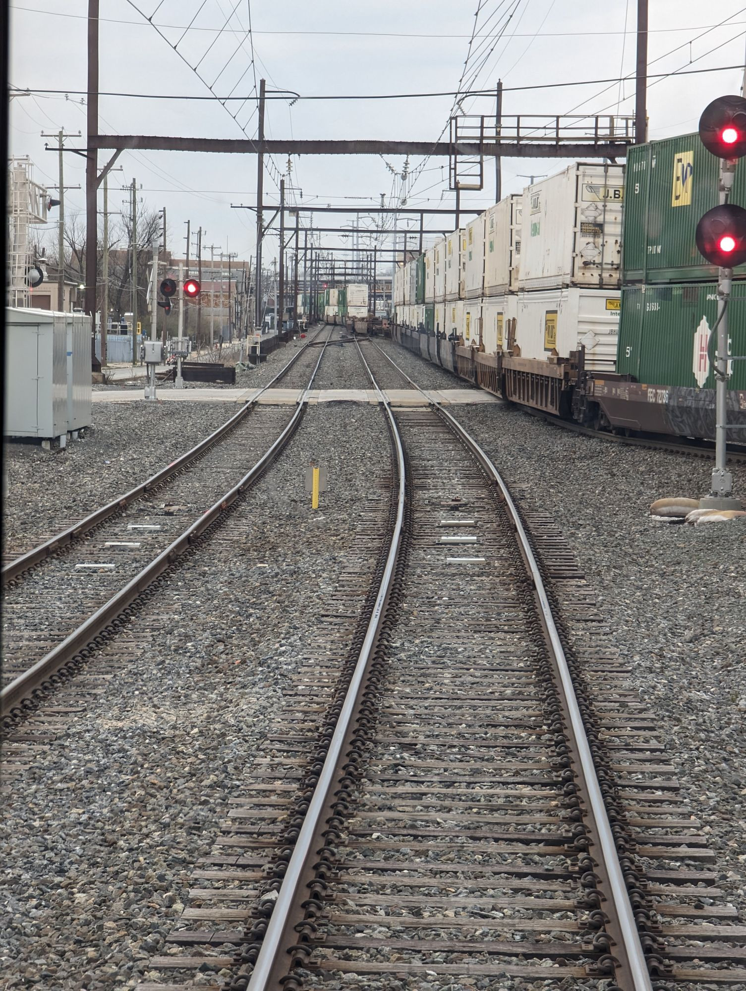 Image of Norfolk Southern freight train carrying double-stacked containers passing beneath SEPTA’s catenary power system.